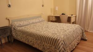 卢恰纳卡斯特路酒店的一间卧室配有一张带桌子和一张书桌的床。