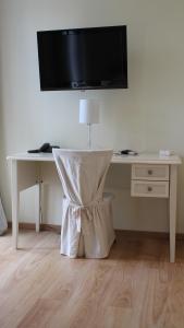 卢恰纳卡斯特路酒店的一张白色的桌子,墙上有电视
