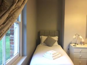 赫恩赫伦肖别墅酒店的一间小卧室,配有一张带窗户的床