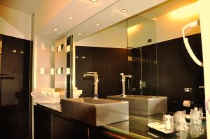 多索博诺维罗纳机场星级酒店的一间带两个盥洗盆和大镜子的浴室