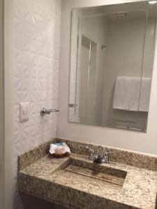 提华纳Hotel Quinta的一间带水槽和镜子的浴室