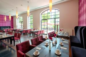 奥芬巴赫ACHAT Hotel Offenbach Plaza的用餐室设有桌椅和窗户。