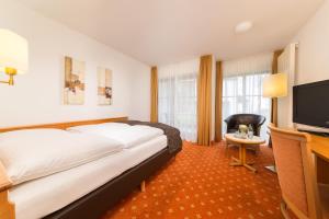 奥托博伊伦巴尔赫伽尼酒店的配有一张床和一台平面电视的酒店客房