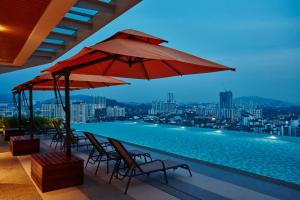 吉隆坡吉隆坡双威伟乐酒店的一个带椅子和红伞的游泳池