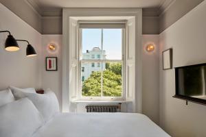 伦敦朝圣者酒店的卧室配有白色的床和窗户。