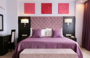 莫斯科宜兹玛罗沃阿尔法酒店的卧室配有一张紫色床,墙上挂着玫瑰花