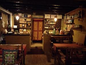 香格里拉香格里拉天依阁客栈的一间设有酒吧的餐厅,并在一间房间内配有桌子