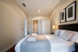 巴塞罗那Tendency Rambla Catalunya的卧室配有一张白色大床和两条毛巾