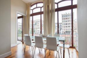 巴塞罗那Tendency Rambla Catalunya的一间带桌椅和大窗户的用餐室