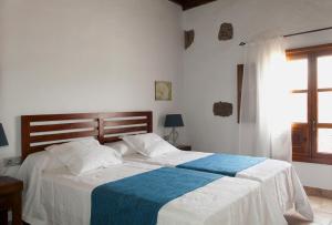 马赫Caserío Leandro III的一间卧室配有一张带蓝白色毯子的床