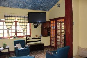 伊皮亚巴斯Hotel Fazenda Sao Sebastiao的客厅配有蓝色椅子和平面电视