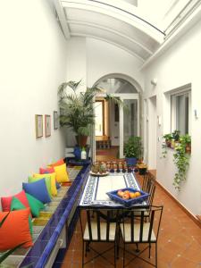 塞维利亚卡萨阿尔法雷利亚59住宿加早餐酒店的客厅配有桌子和色彩缤纷的枕头