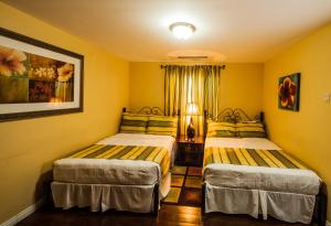 西班牙港87号酒店的黄色墙壁客房的两张床