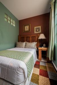 西班牙港87号酒店的一间卧室配有一张床和一张带台灯的桌子