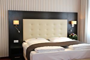 柏林斯特柏林酒店的一间卧室配有一张大床和黑色床头板