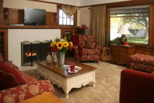 洛迪Cottage on Armstrong的客厅设有壁炉和带鲜花的桌子。