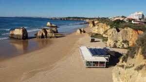 波尔蒂芒Villa Figueira的海滩上设有太阳能电池板的建筑