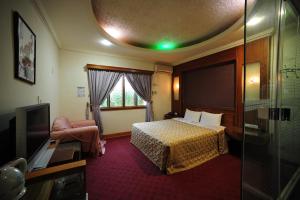 新竹金座渡假汽车旅馆的一间酒店客房,配有一张床和一台电视