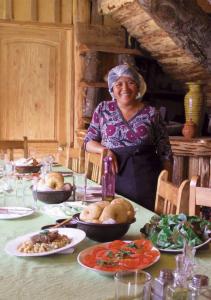 梅利佩乌科Hospedaje y Agrocamping Relmucura的站在餐桌前吃饭的女人