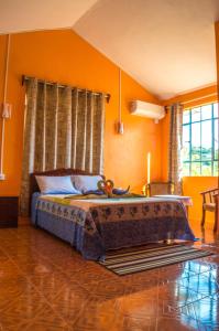 Rodrigues IslandMerlin Guest House的一间卧室配有橙色墙壁的床