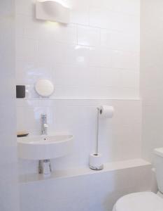 卡迪根The Art Room Apartment的白色的浴室设有水槽和卫生间。