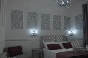 热那亚Ca dei Nobili的一间卧室配有两张床、一把椅子和一个吊灯。