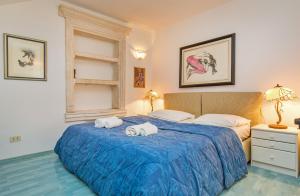 杜布罗夫尼克Villa Leora Dubrovnik的一间卧室配有蓝色的床和毛巾