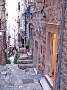 杜布罗夫尼克Villa Leora Dubrovnik的老城区的小巷,有楼梯和建筑