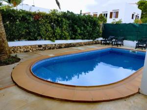 卡拉恩·布拉內斯Grupoandria Villa Dora的庭院内的游泳池,庭院内带有庭院和桌子
