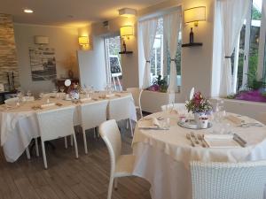 TeoloVilla Lussana的用餐室配有白色的桌子和白色的椅子