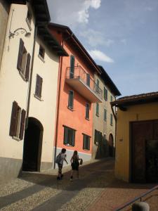 Coldrerio提美公寓酒店的两个人沿着建筑物旁边的街道走