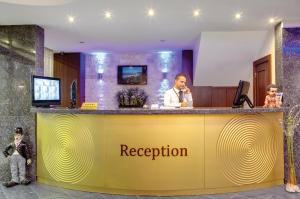 伊兹密尔苏苏祖鲁赛金酒店的一家旅馆的一个接待台,有一个人在电话上讲话