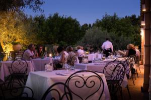 San Corrado di Fuori马赛利亚德格里乌里维酒店的一群坐在桌子上的人,用白色桌布