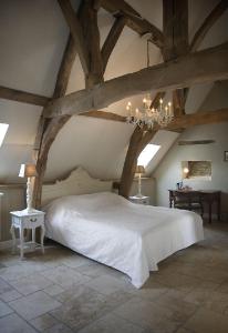 富伦奥伯格拉温霍夫酒店的卧室配有一张白色大床和吊灯。