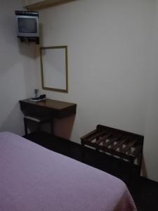 蓬塔德尔加达Estalagem Corte do Norte的一间卧室配有一张床、一张书桌和一面镜子
