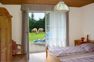 比绍夫斯格林Ferienwohnung Hopfennest的卧室配有一张床,外面设有推拉玻璃门,配有马匹