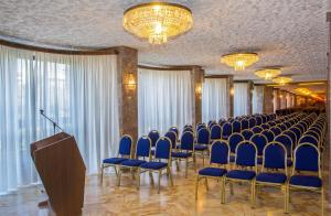 塔兰托广场酒店的一间会议室,配有蓝色椅子和讲台