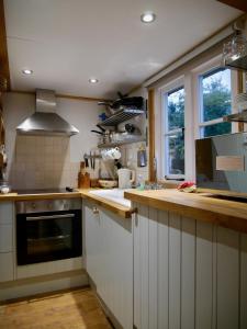博利厄Wayside Cottage的厨房配有白色橱柜、水槽和窗户。