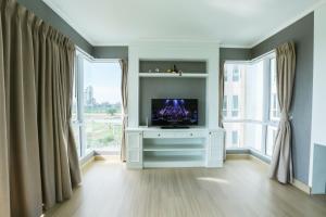 邦萨雷博安邦萨拉伊精品1号公寓的客厅设有电视,位于带窗户的白色橱柜上