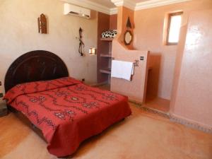 IchtBorj Biramane的一间卧室配有红色的床和冰箱