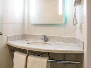 阿拉萨图巴ibis Araçatuba的浴室配有盥洗盆、镜子和毛巾