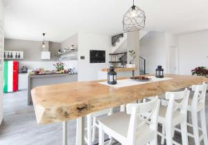 韦尔巴尼亚B&B Stella Maggiore的厨房里配有一张大木桌和白色的椅子