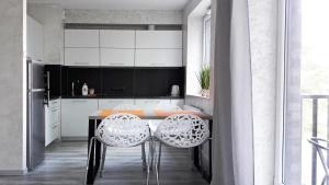 弗罗茨瓦夫Art Apartments的厨房配有桌子和两把白色椅子