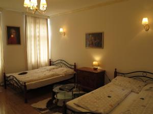 维也纳卡皮托小型豪华公寓的一间卧室配有两张床、一张桌子和两盏灯。