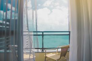 福塔莱萨JOH Blue Ocean Flat Hotel的阳台配有两把椅子,享有海景。