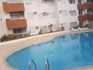 弗洛里亚诺波利斯Apto de 02 qtos no Ingleses - Florianopolis - SC的大楼前的大型游泳池