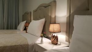 PichanakiTerraza Apart Hotel的一间卧室配有两张床和床头灯。