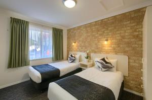 奥尔巴尼佩里肯斯奥尔巴尼米德尔顿海滩酒店的酒店客房带两张床和砖墙