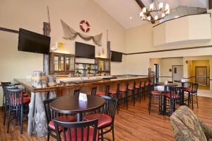 EmoryBest Western Plus Emory at Lake Fork Inn & Suites的餐厅内的酒吧配有桌椅