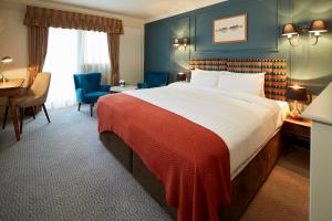 斯蒂夫尼奇Hotel Cromwell Stevenage的酒店客房设有一张大床和一张书桌。